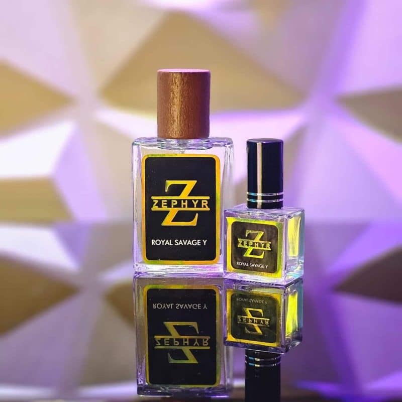 Zephyr Royal Savage Y concentrated perfume oil clear glass bottles in 30ml with wooden cap and 10ml with black cap on a dark reflective surface.